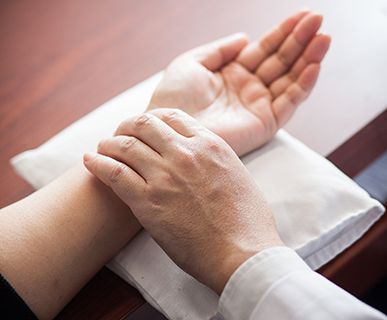 Close-up of TCM practitioner's hand on a patient's left wrist