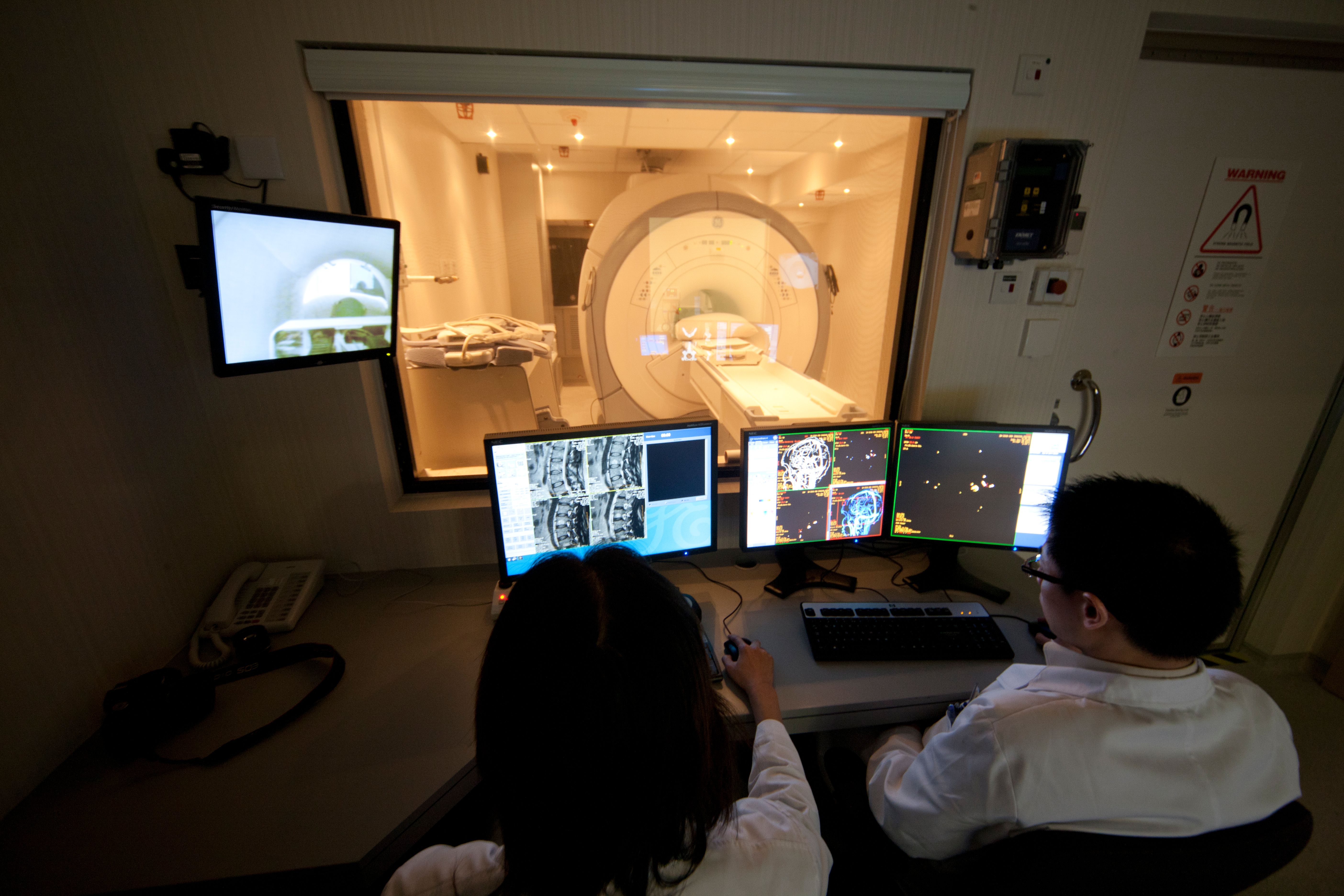 Two medical professionals reviewing diagnostic imaging results in a dark room
