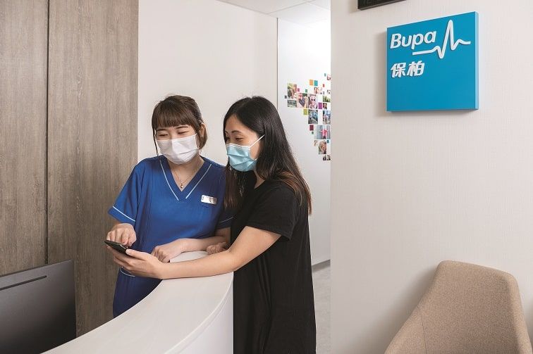 Female nurse and patient at Bupa Medical Centre reception