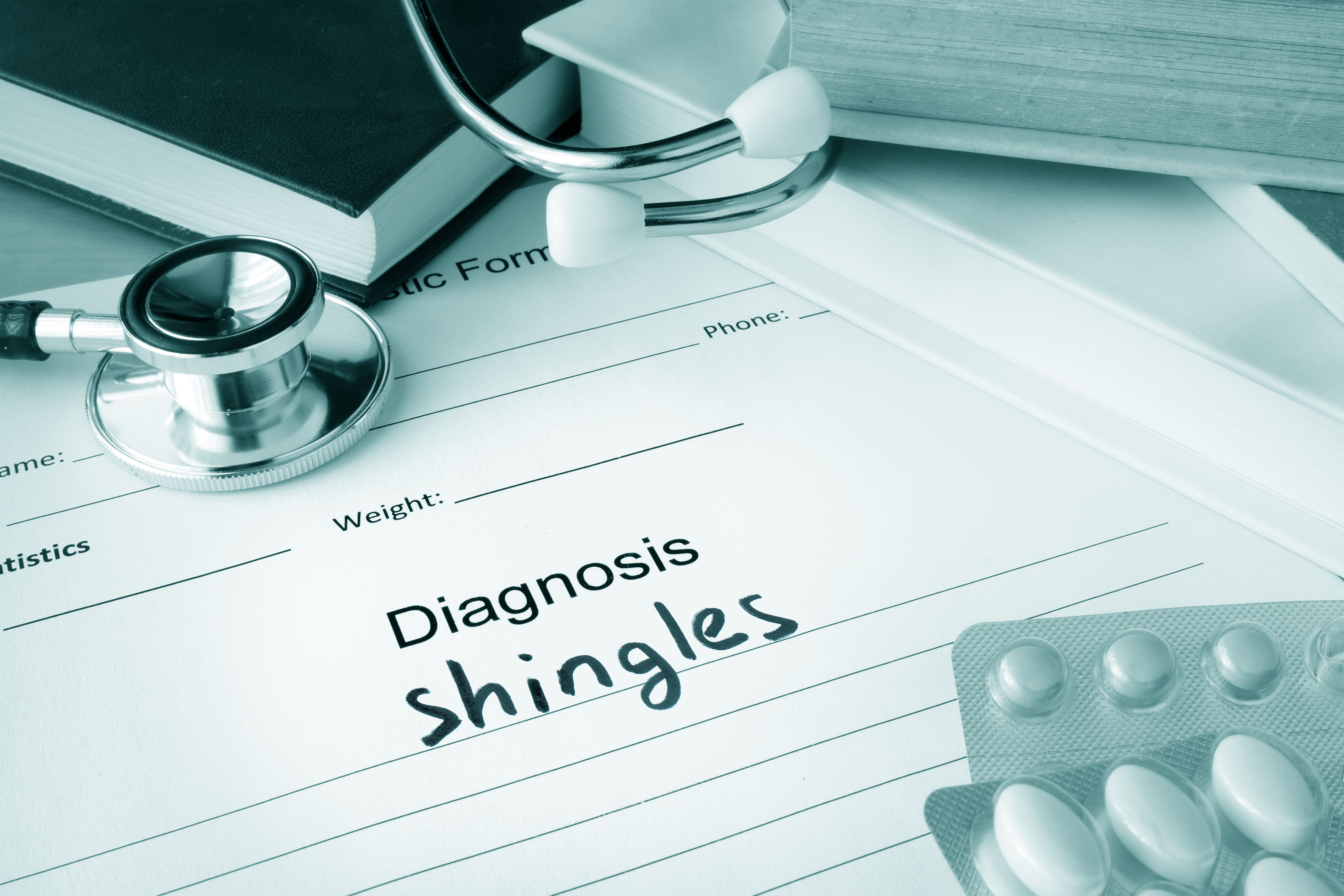 Close-up of a patient chart with the diagnosis of "shingles" written on
