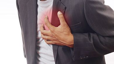 Close-up of man clutching his painful heart with left hand
