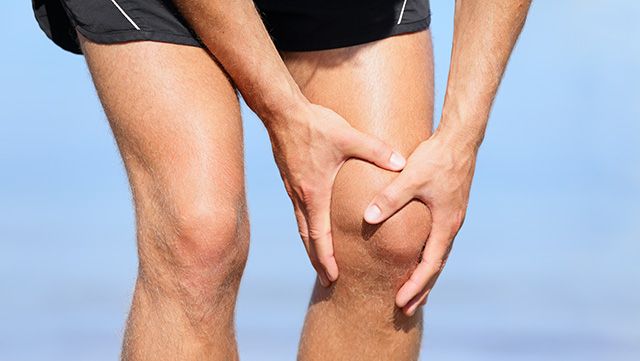 Man grabbing painful knee with both hands