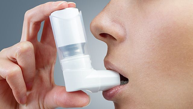 Close-up of female patient using an oral inhaler