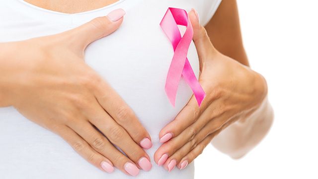 Woman highlighting a pink breast cancer ribbon on her chest
