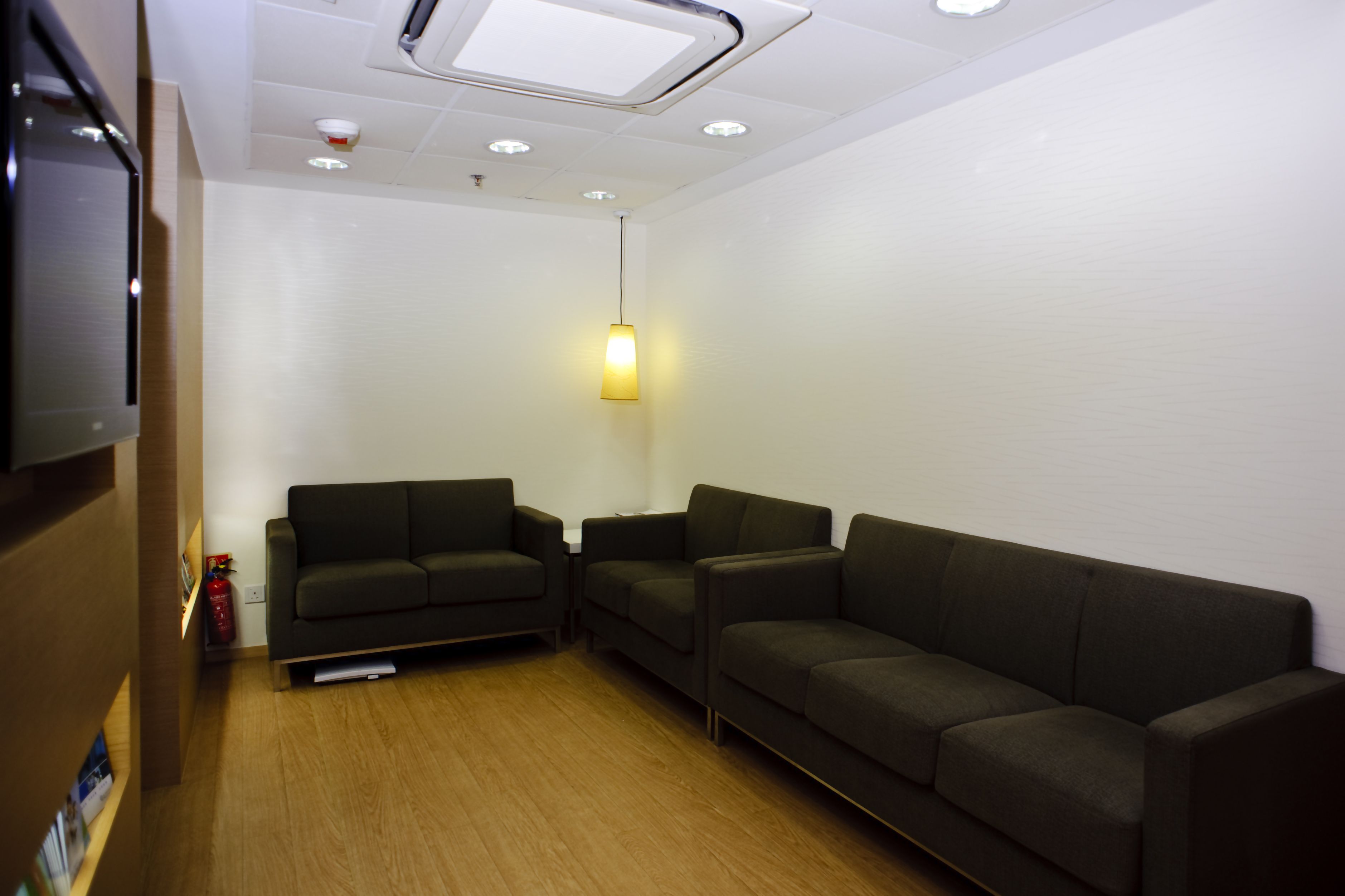 Medical centre waiting room with sofas and flat-screen TV