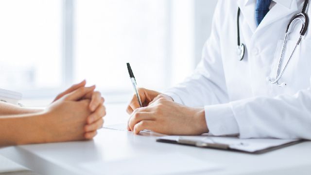 Doctor writing in patient's chart