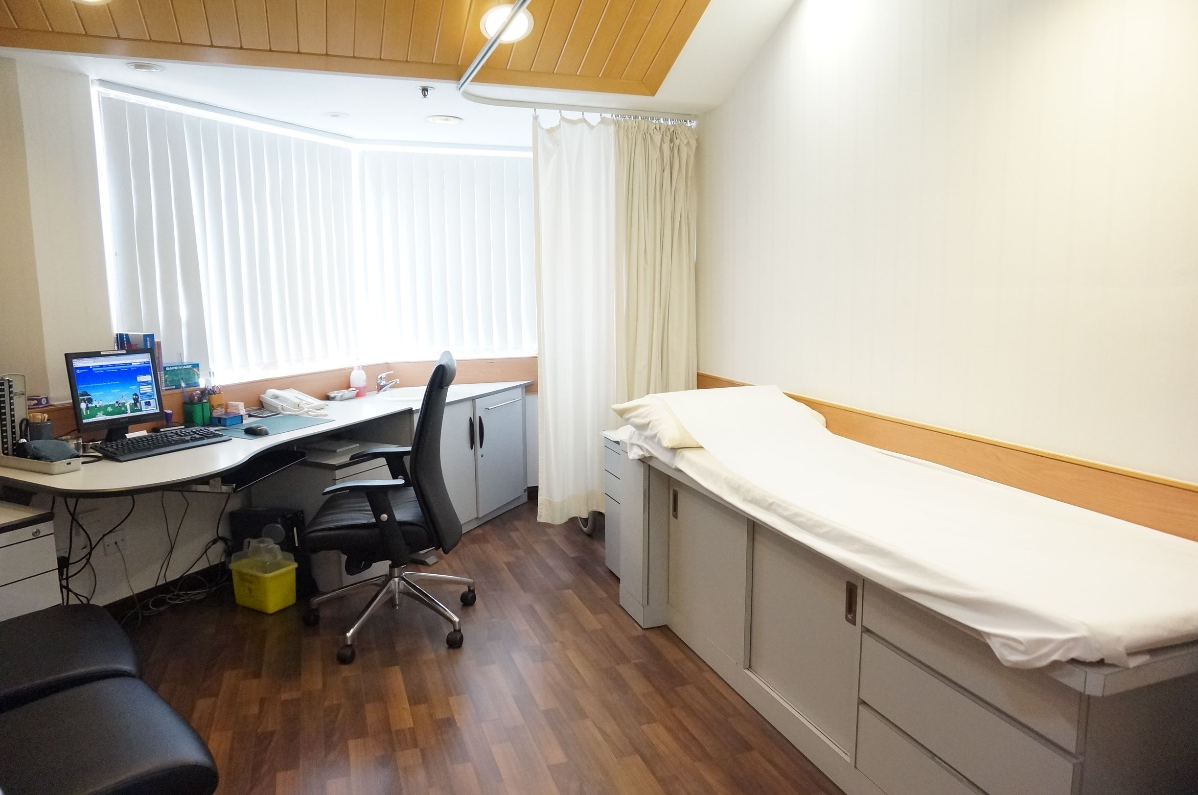 Consultation room with patient bed and desk