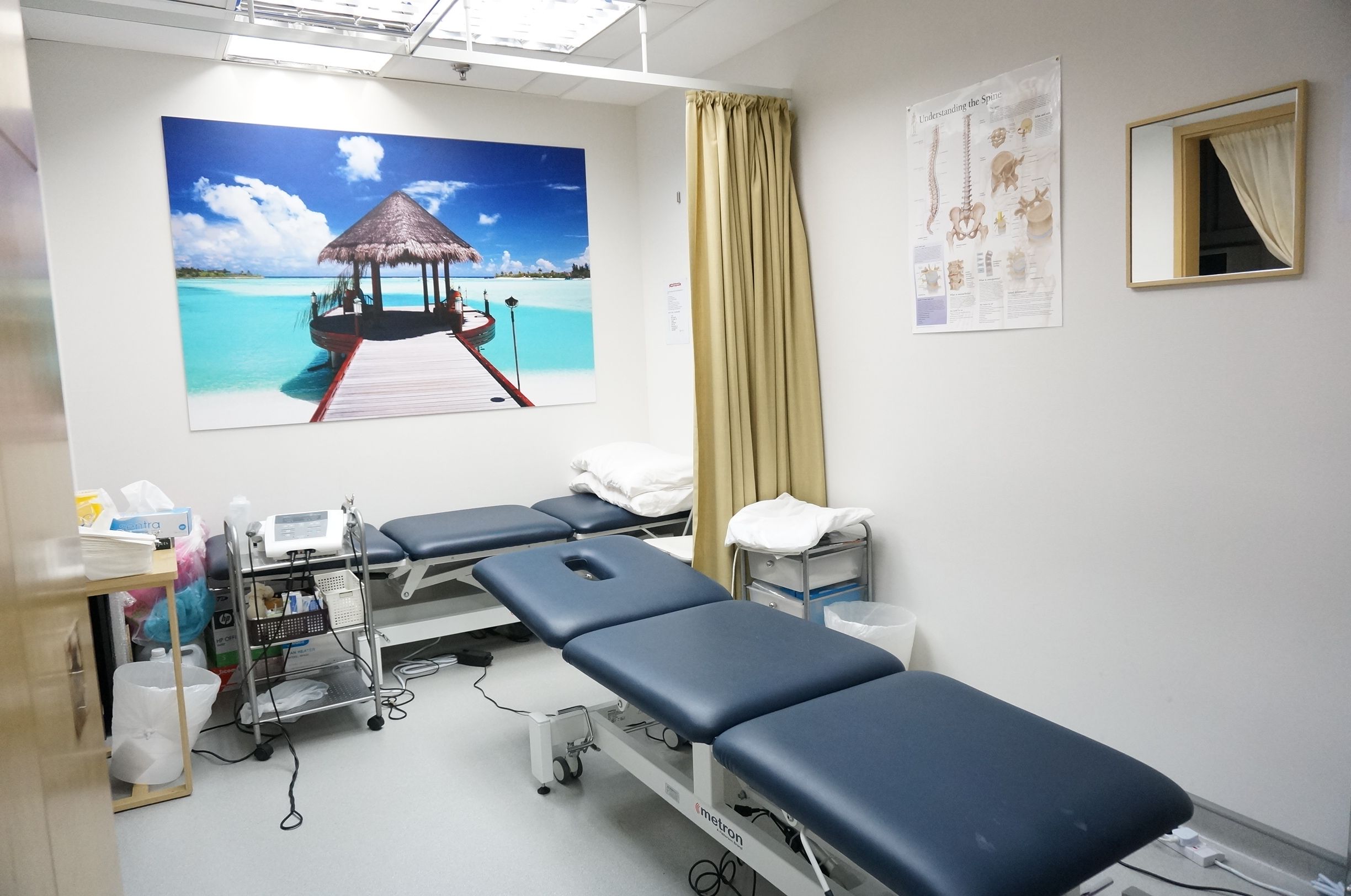 Two physiotherapy beds in a room that can be divided by a curtain