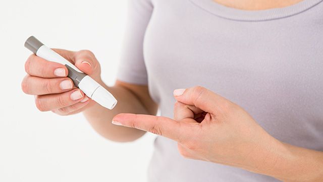 Woman pricking her finger to test blood sugar