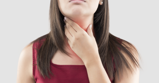Woman holding sore throat with one hand