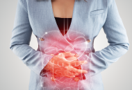 Woman holding her abdomen with superimposed illustration of the digestive system