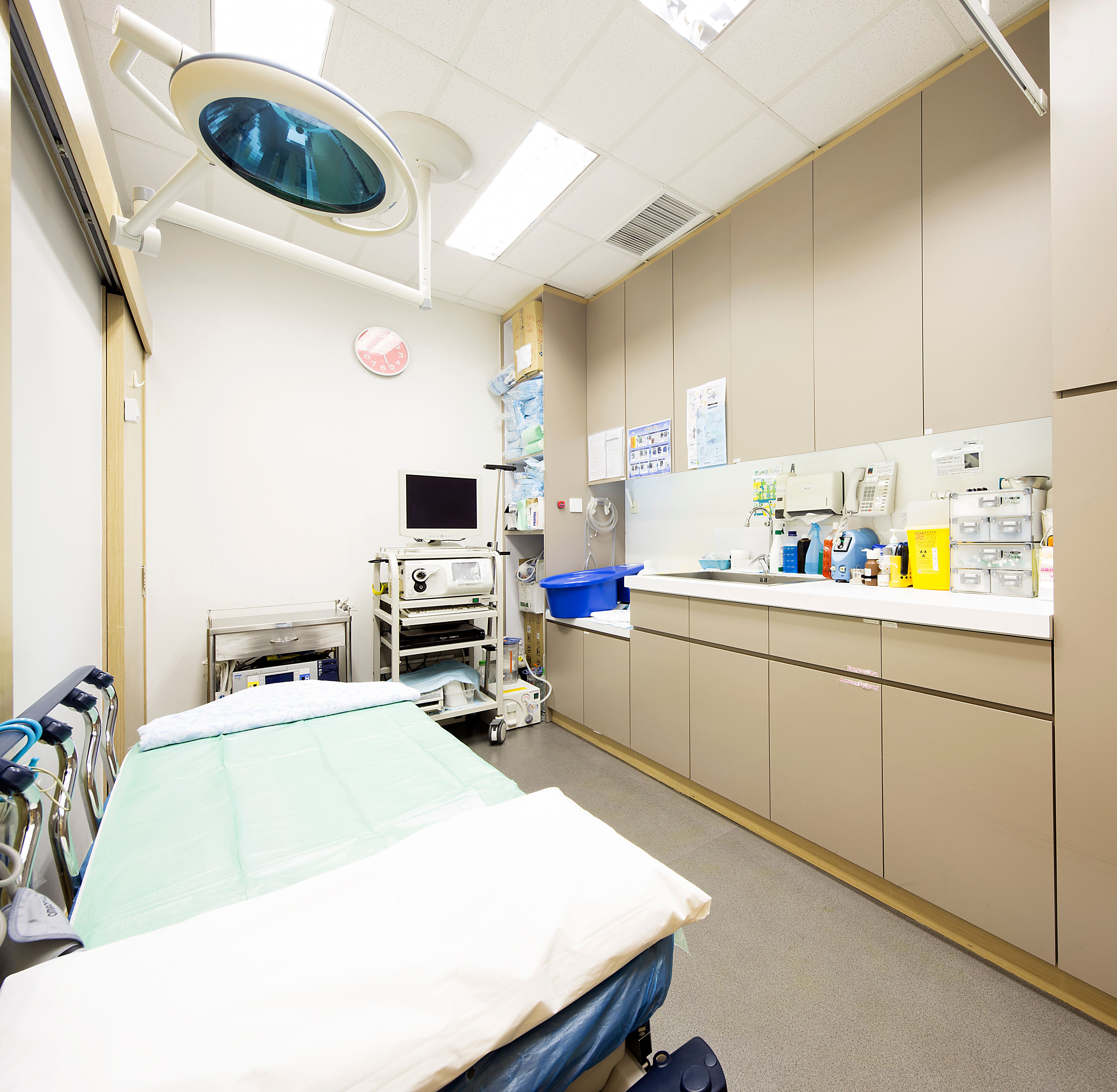 Examination room with patient bed, medical equipment and cabinets