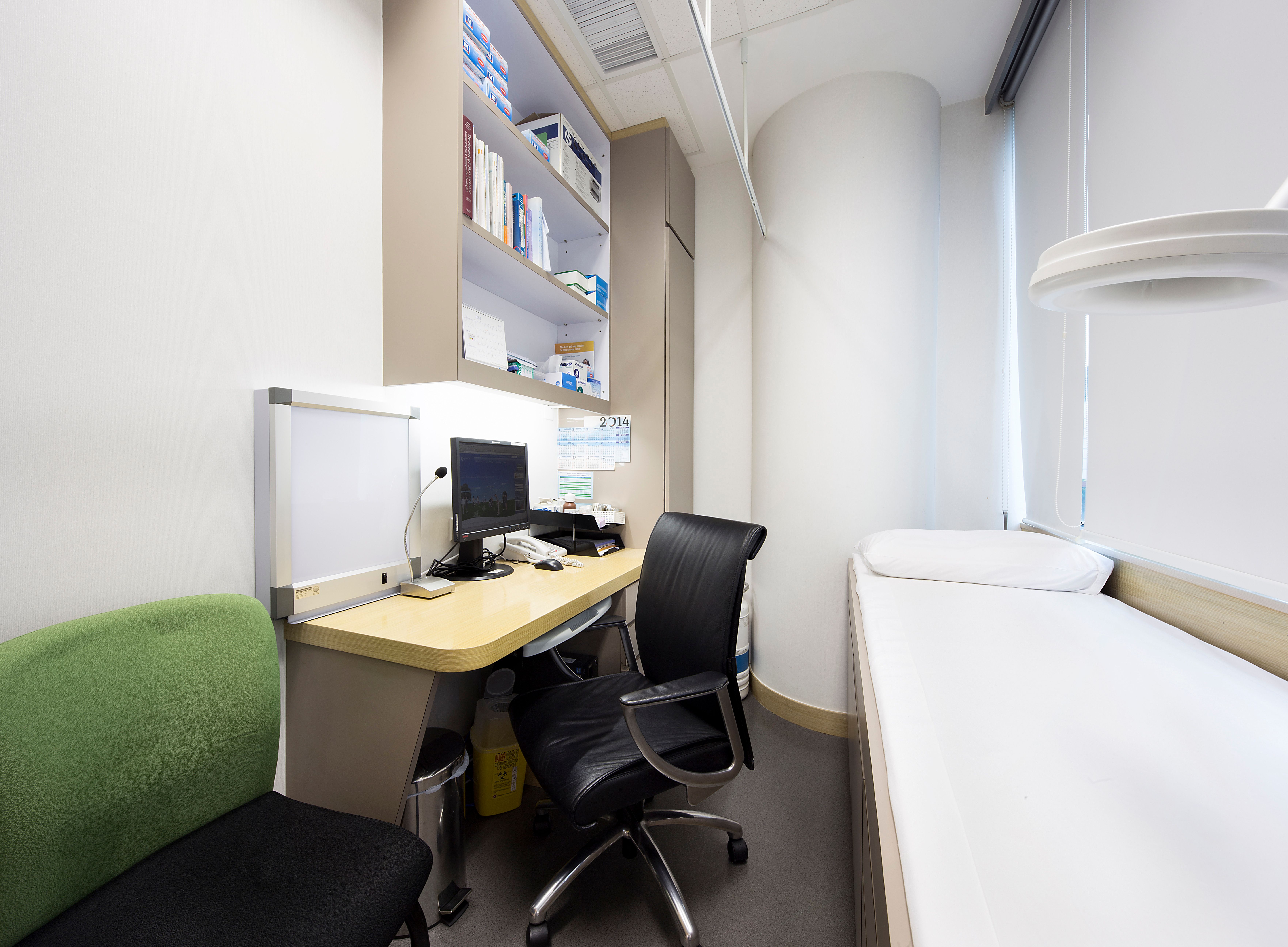 Consultation room with patient bed and desk