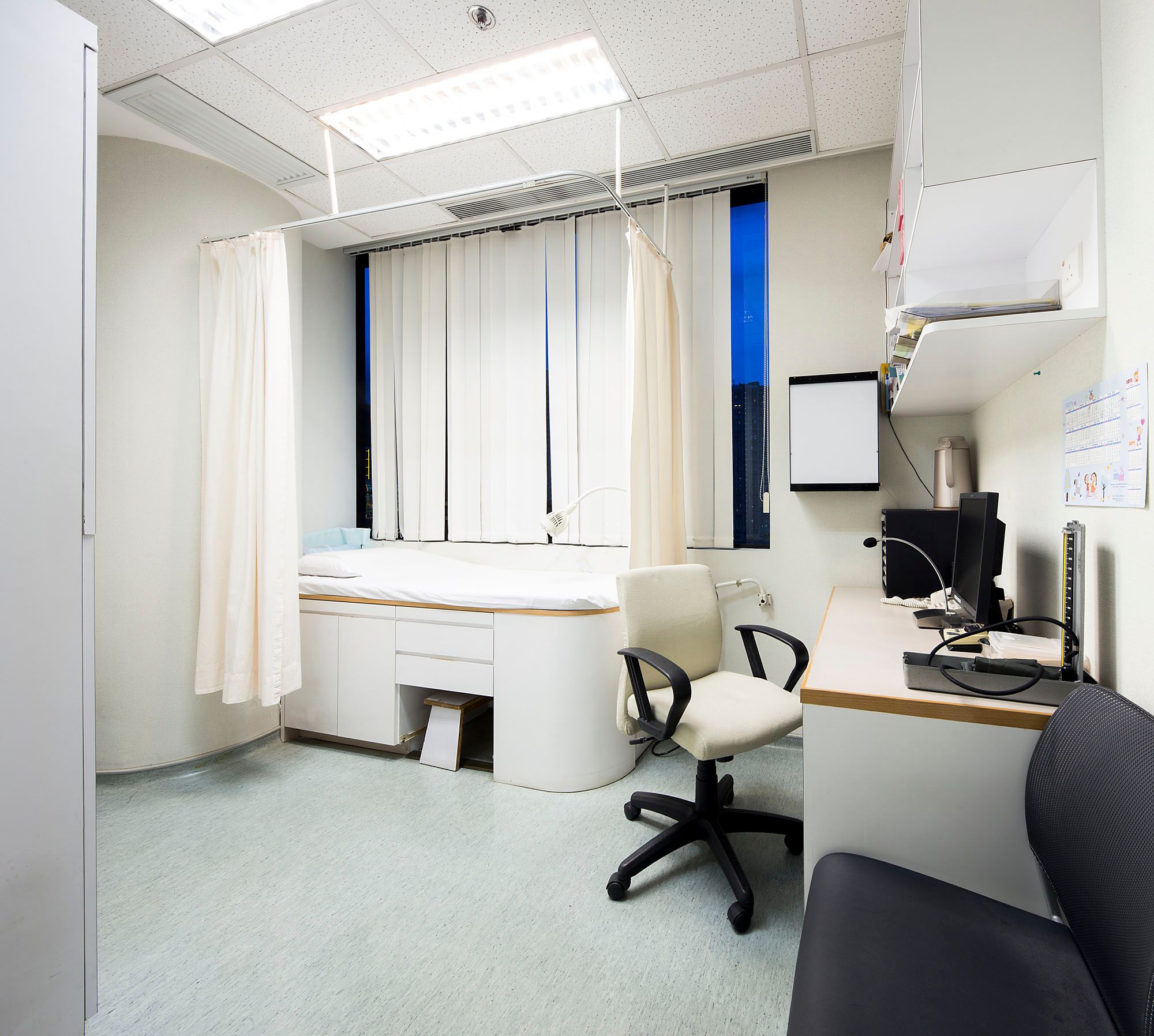 Consultation room with patient bed and desk