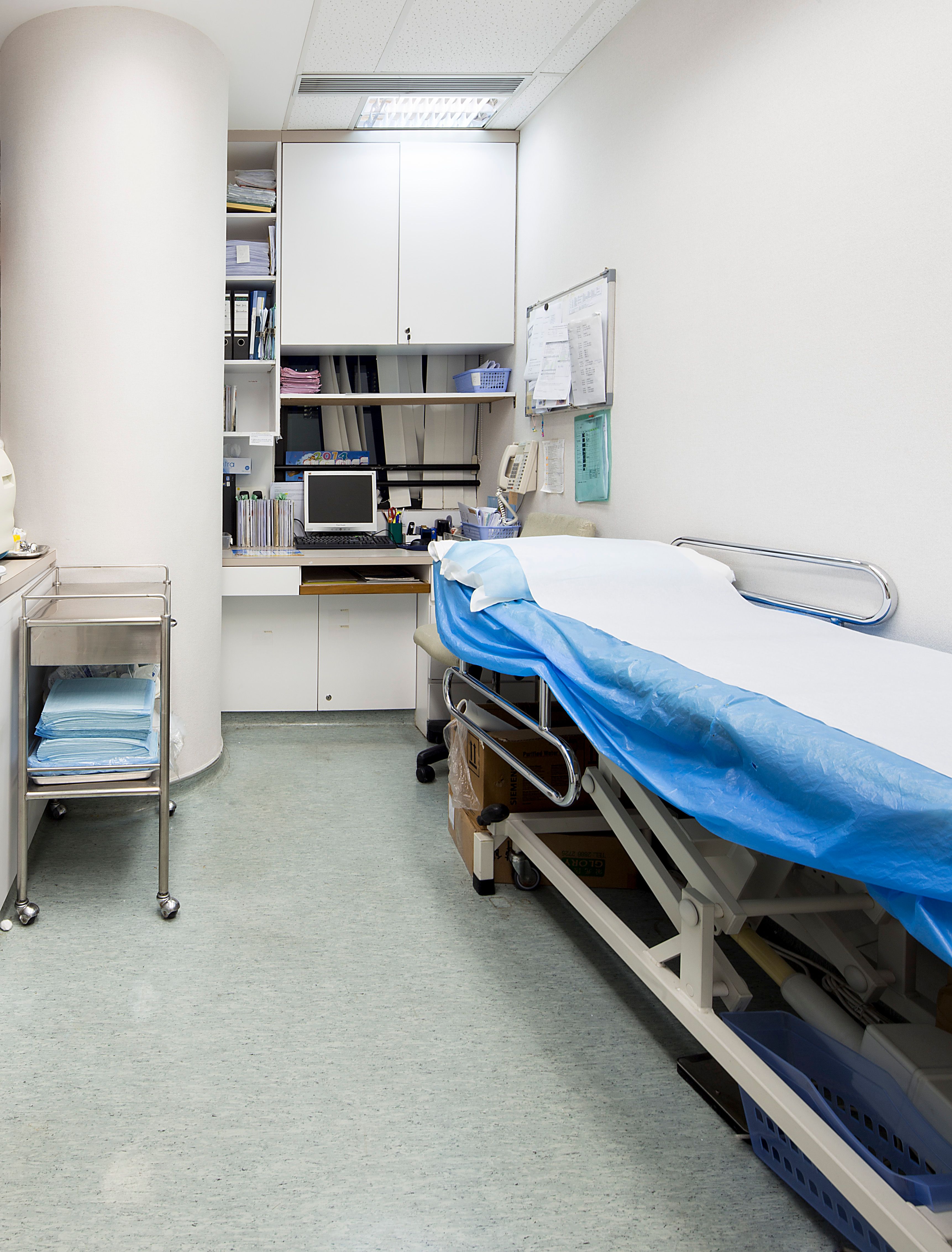 Examination room with patient bed and cabinets