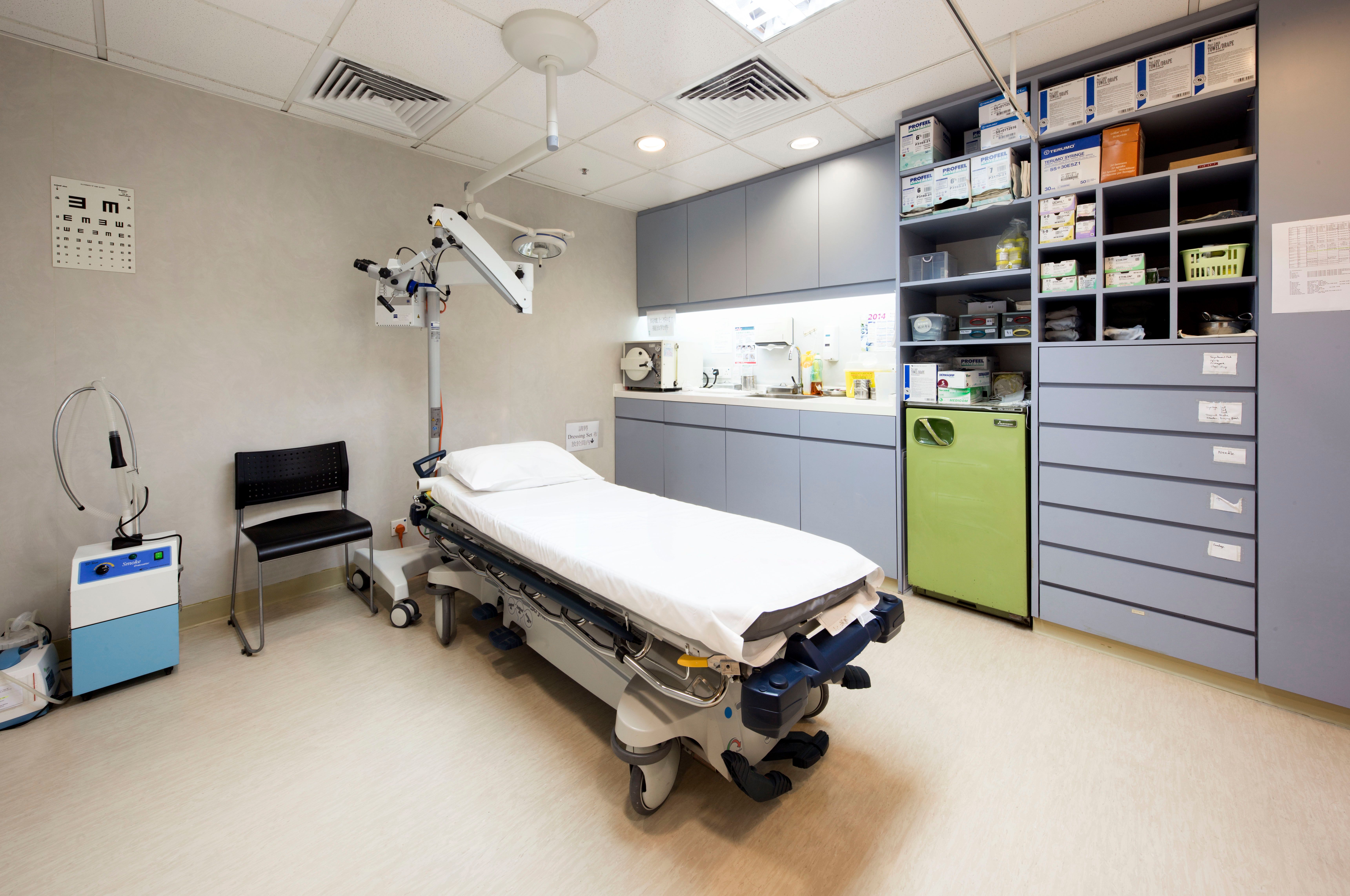 Procedure room with patient bed and storage cabinets