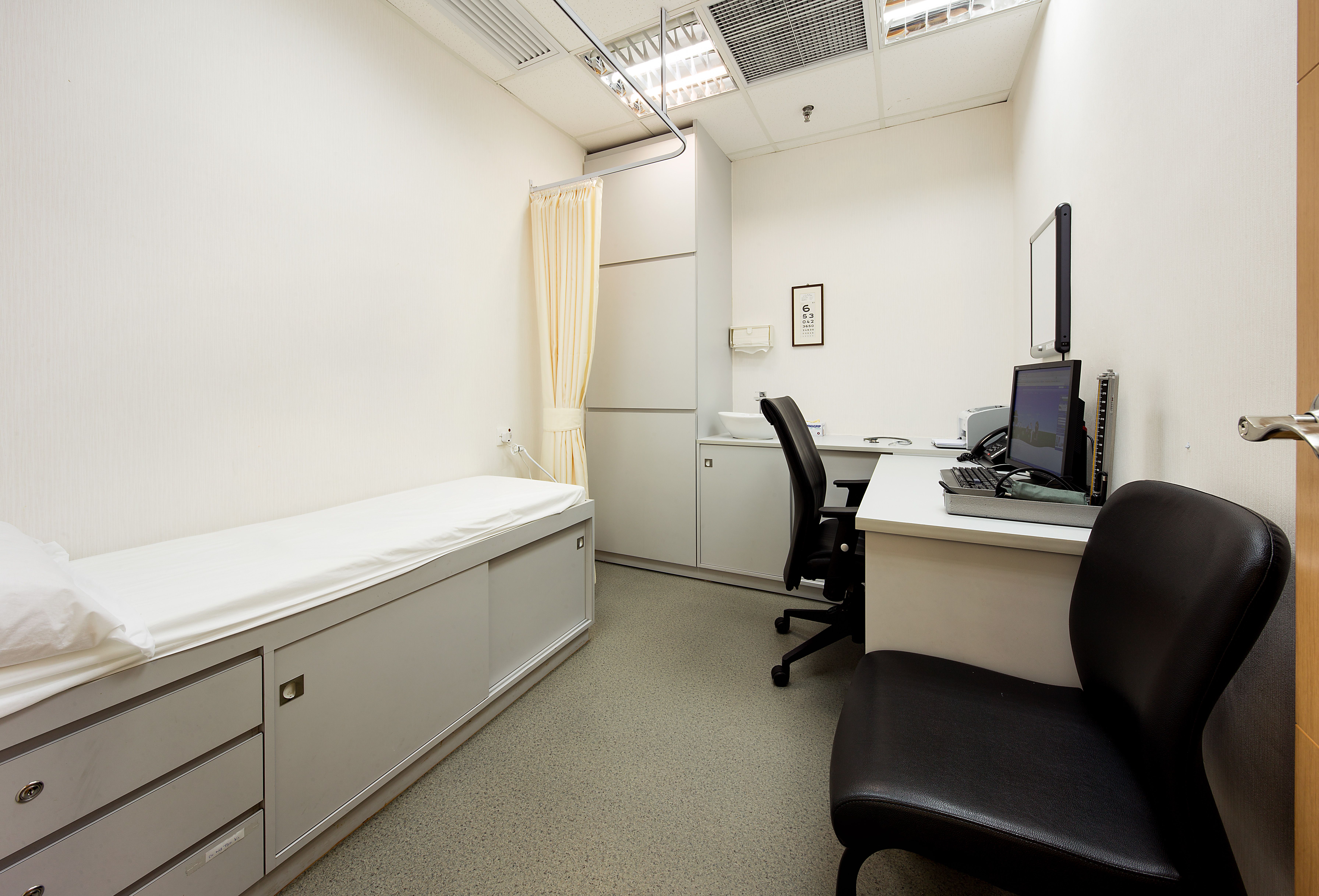 Consultation room with desk and patient bed
