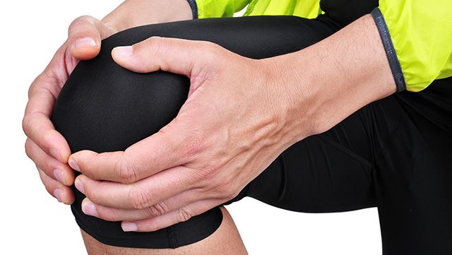 Two hands holding painful knee