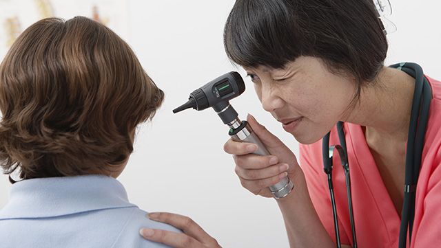 Female doctor examining patient's ear