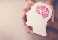Two pairs of hands holding the outline of a head with a brain inside