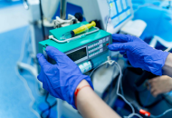 Close-up of gloved hands on equipment in the operating room