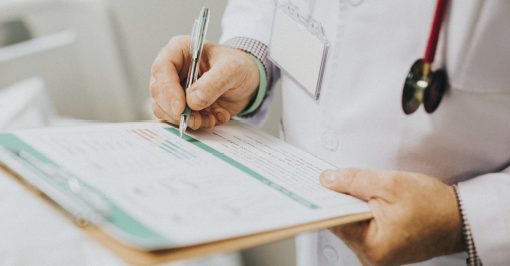 Doctor writing on patient chart