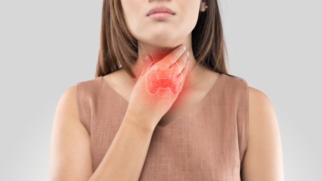 Woman holding the front of her painful neck