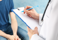 Doctor writing in a patient's chart