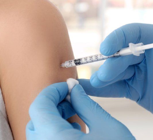 Close-up of a person receiving an injection in the arm