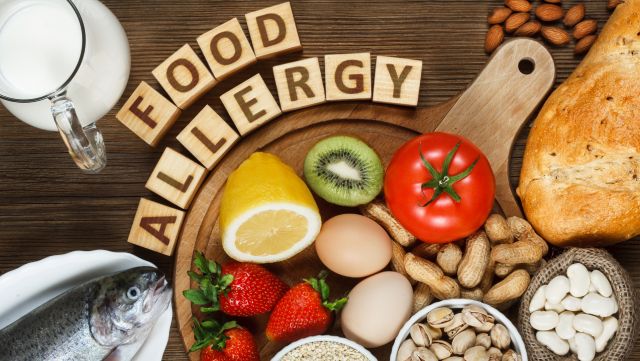 Food on a cutting board with wooden blocks spelling Food Allergy