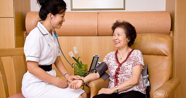 Nurse taking an elderly woman's blood pressure