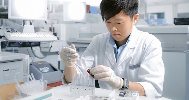 Laboratory technician with test tubes