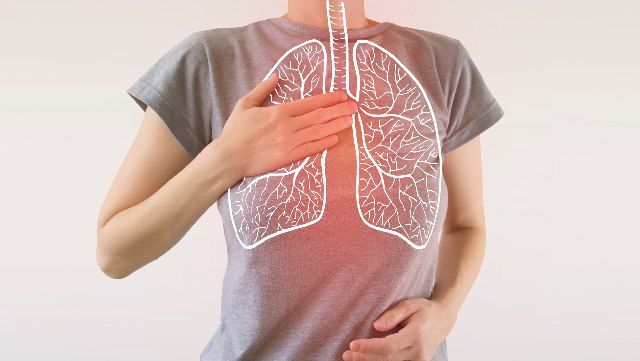 Woman with one hand on her chest and superimposed illustration of the lungs