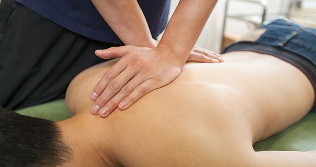Physiotherapist massaging patient's back