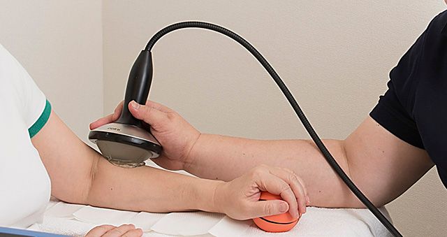 Physiotherapist performing ultrasound on a patient's elbow