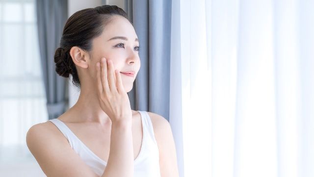 Woman touching her cheek and looking into the distance