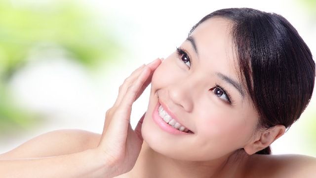 Smiling woman touching her face and tilting her head
