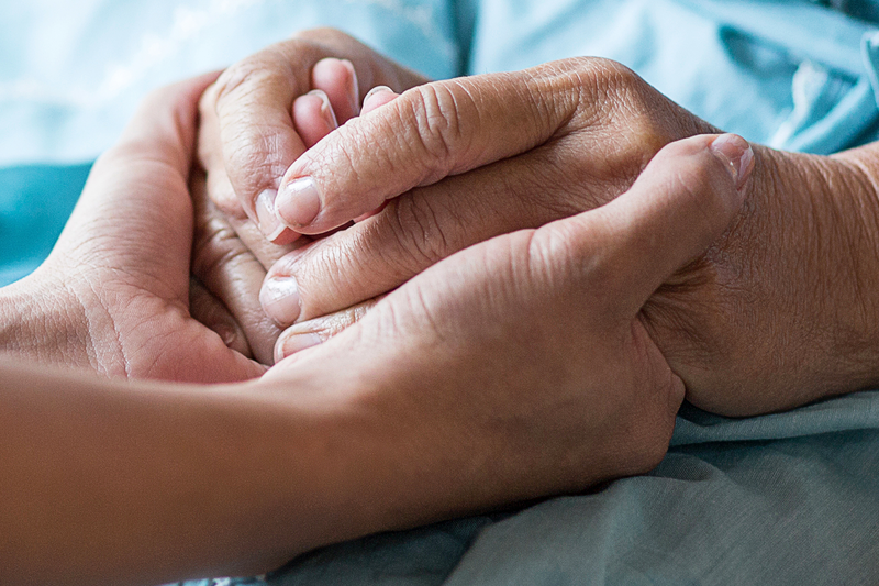 a young hand holding an old hand