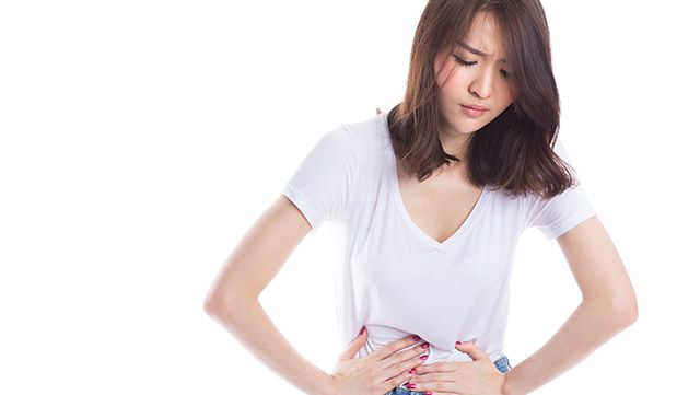 Woman with both hands on her abdomen in pain
